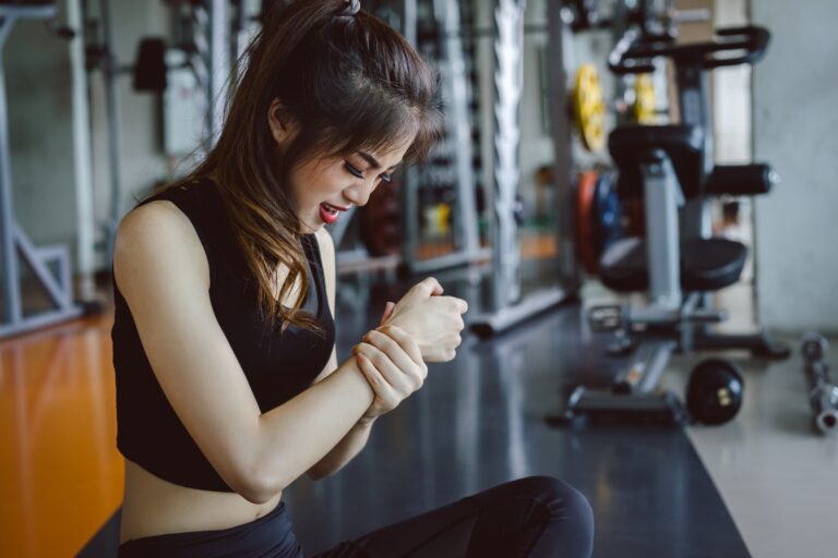 Woman doing sport exercise injury arm accident at gym fitness, Safety body concept.