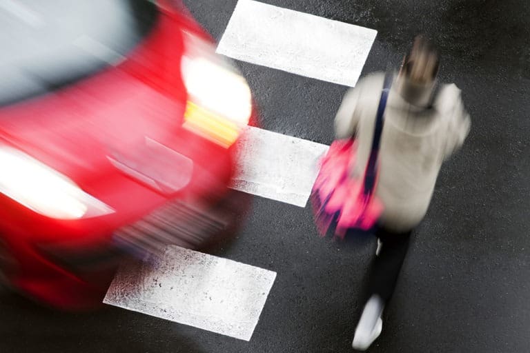 female pedestrian crossing the street about to get hit