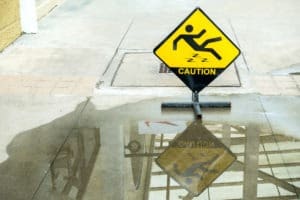 caution sign by a huge puddle of water