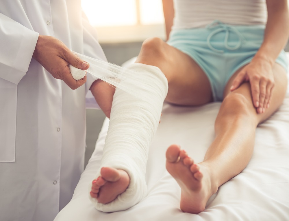 doctor bandaging a woman’s leg