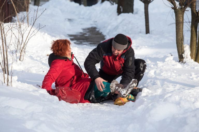 man helping woman on a snowy road