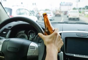 driver holding alcoholic bottle while driving