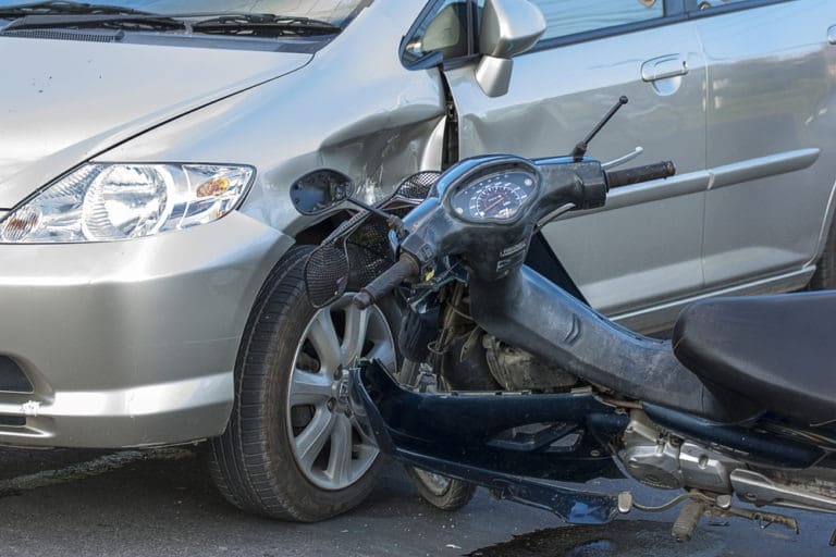 motorcycle colliding with a compact car