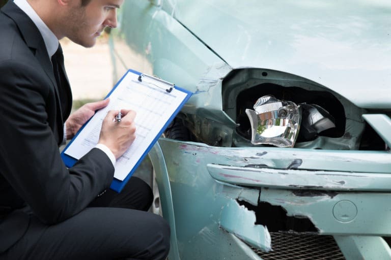 insurance adjuster noting car damage