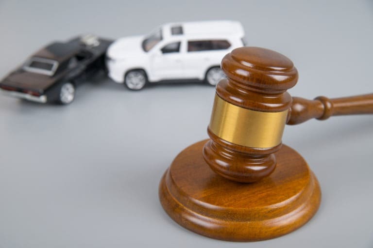 judge’s gavel with model car crash in background