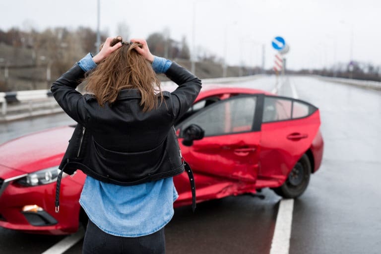 woman surveying damage to her car