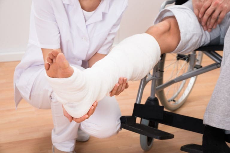 doctor holding patient’s leg in a cast