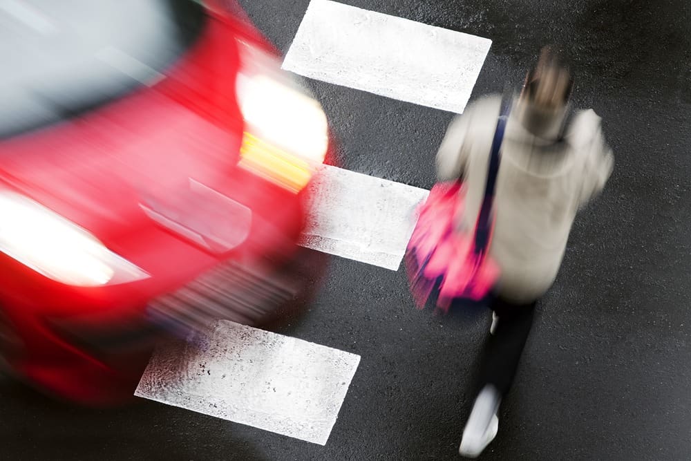 car approaching woman in a car