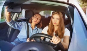 teen girl driving with her mother