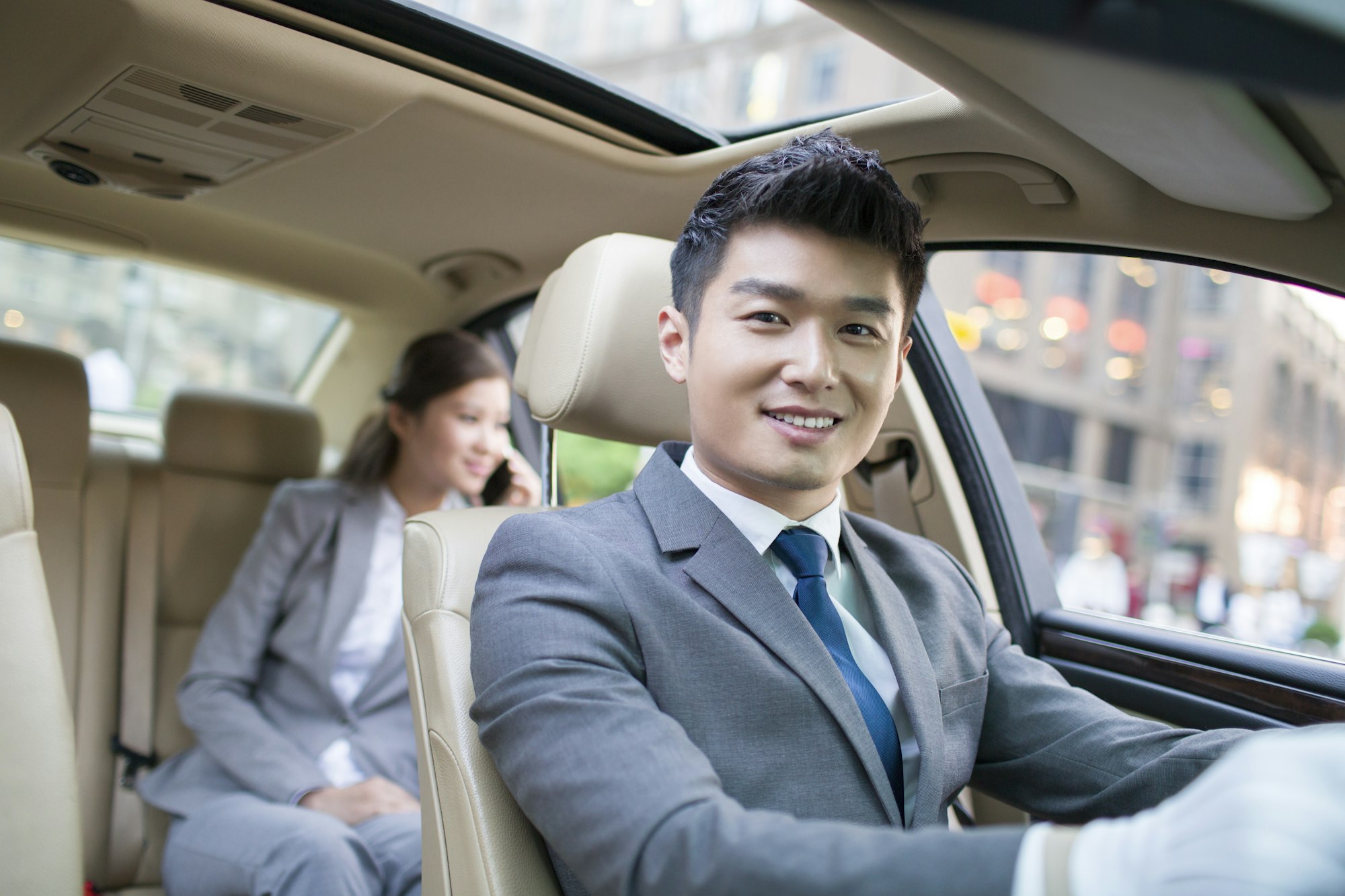 Chauffeur driving car for a businesswoman