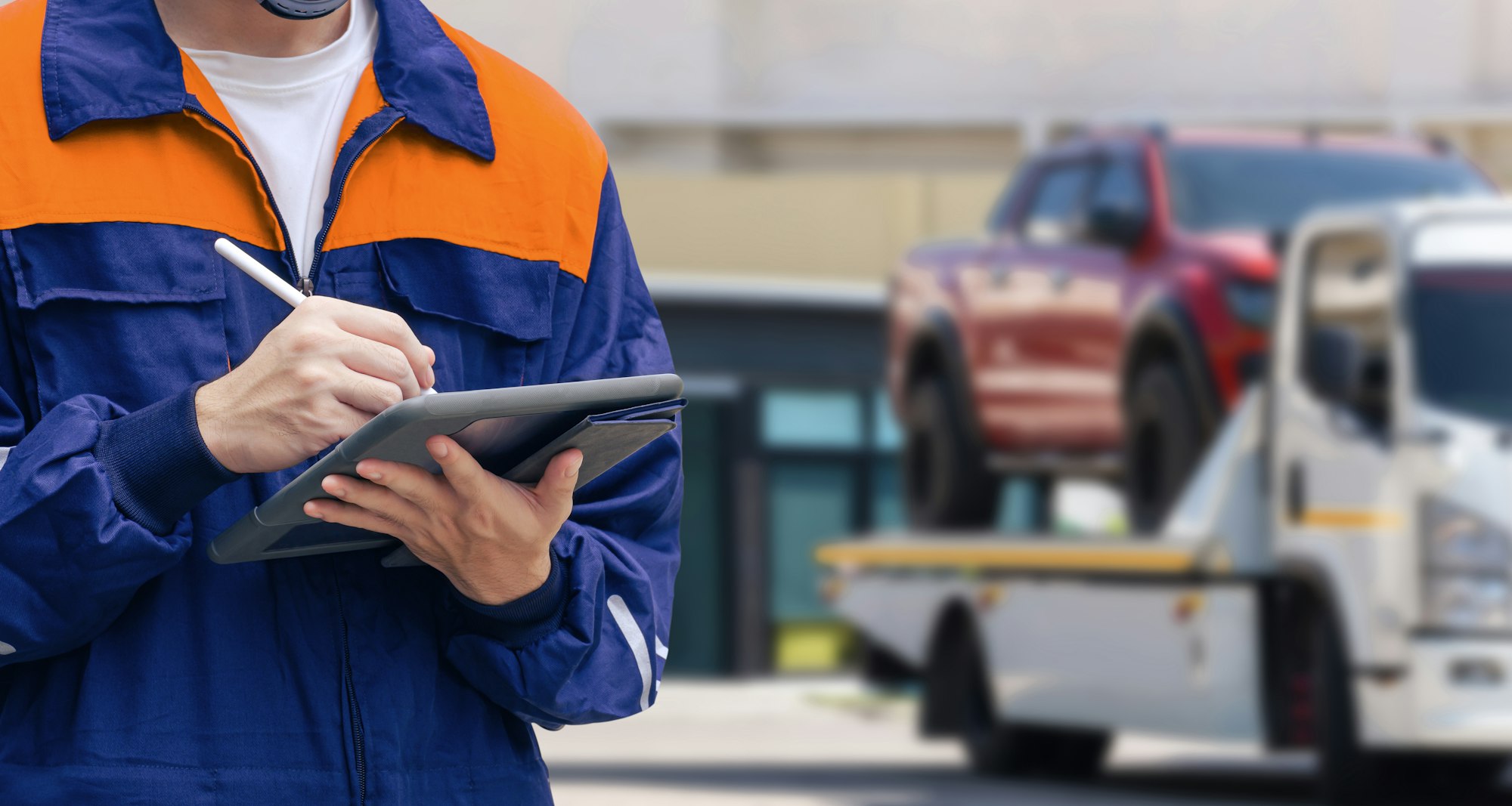 Man recording data of broken pickup car on tablet for transporting to garage after accident
