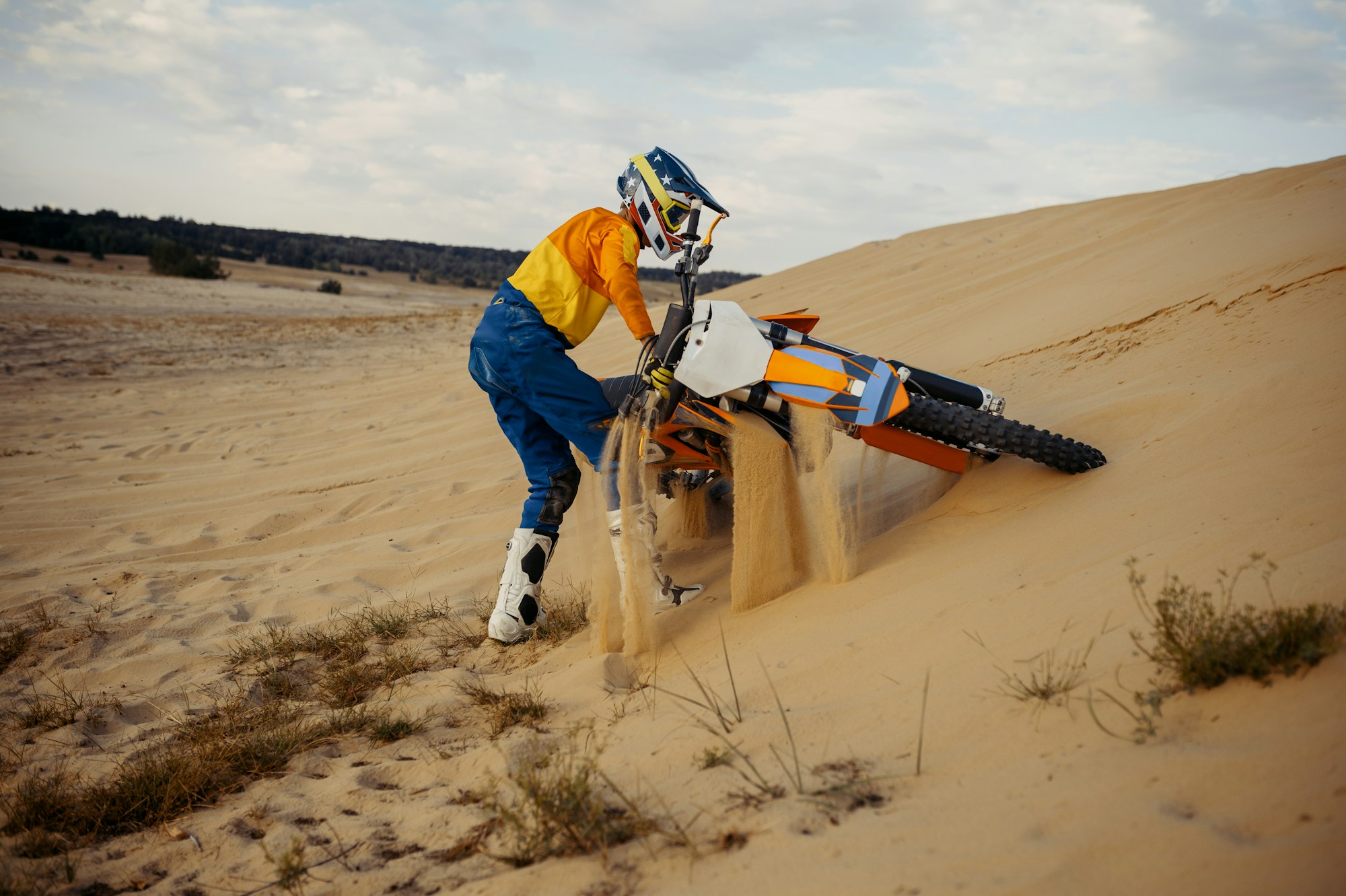 Motocross rider in helmet picks up scooter