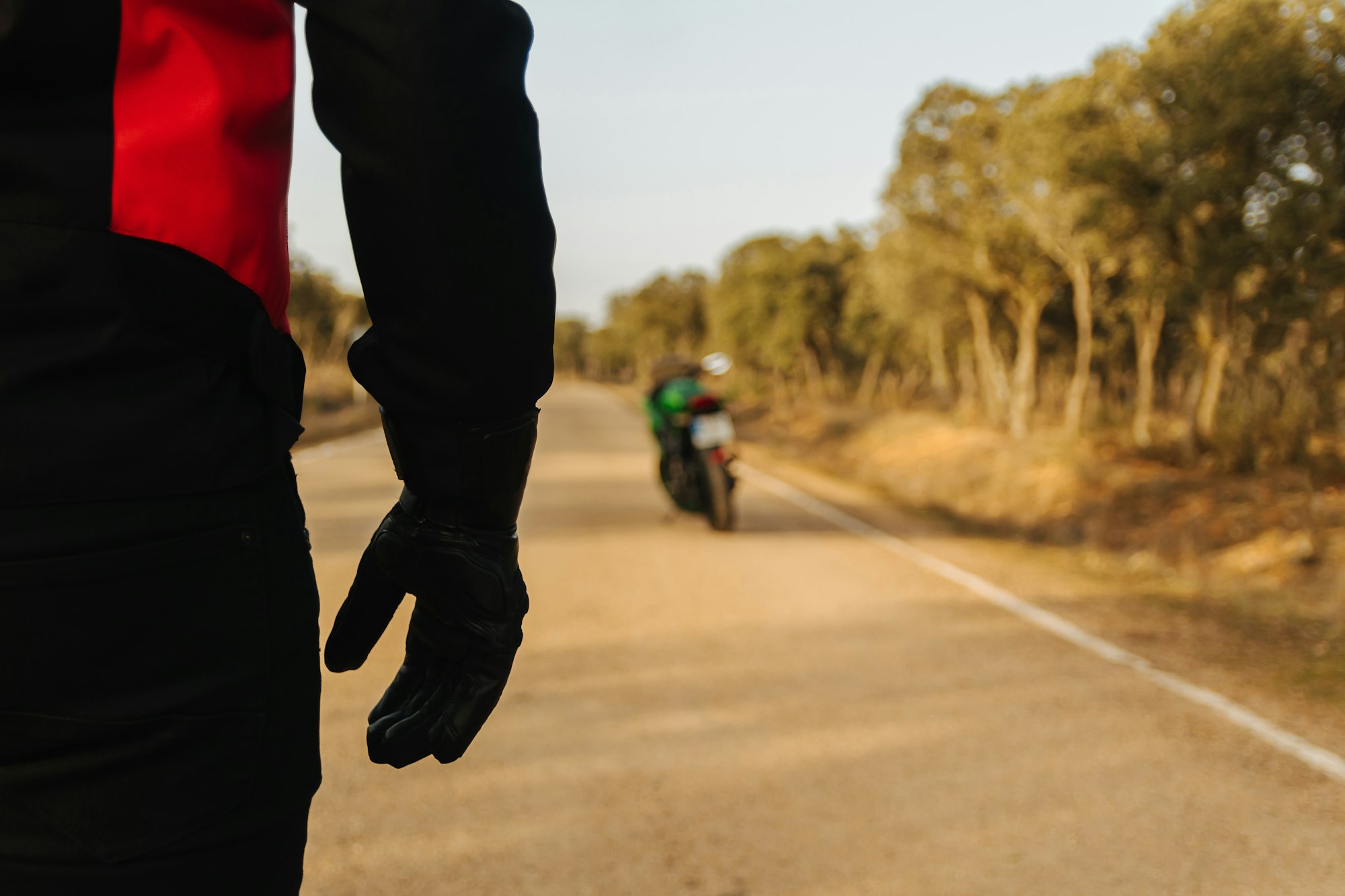 motorcyclist walking towards his motorcycle on the road