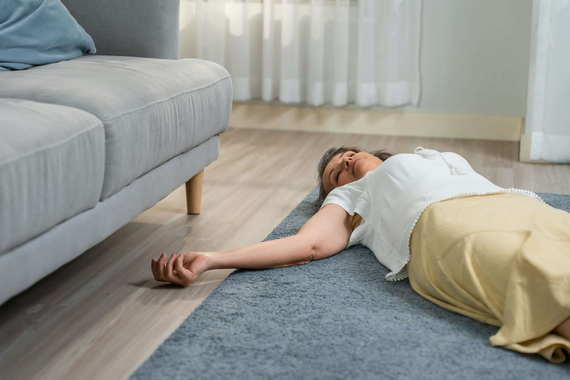Caucasian senior woman fall on the ground alone in living room at home.