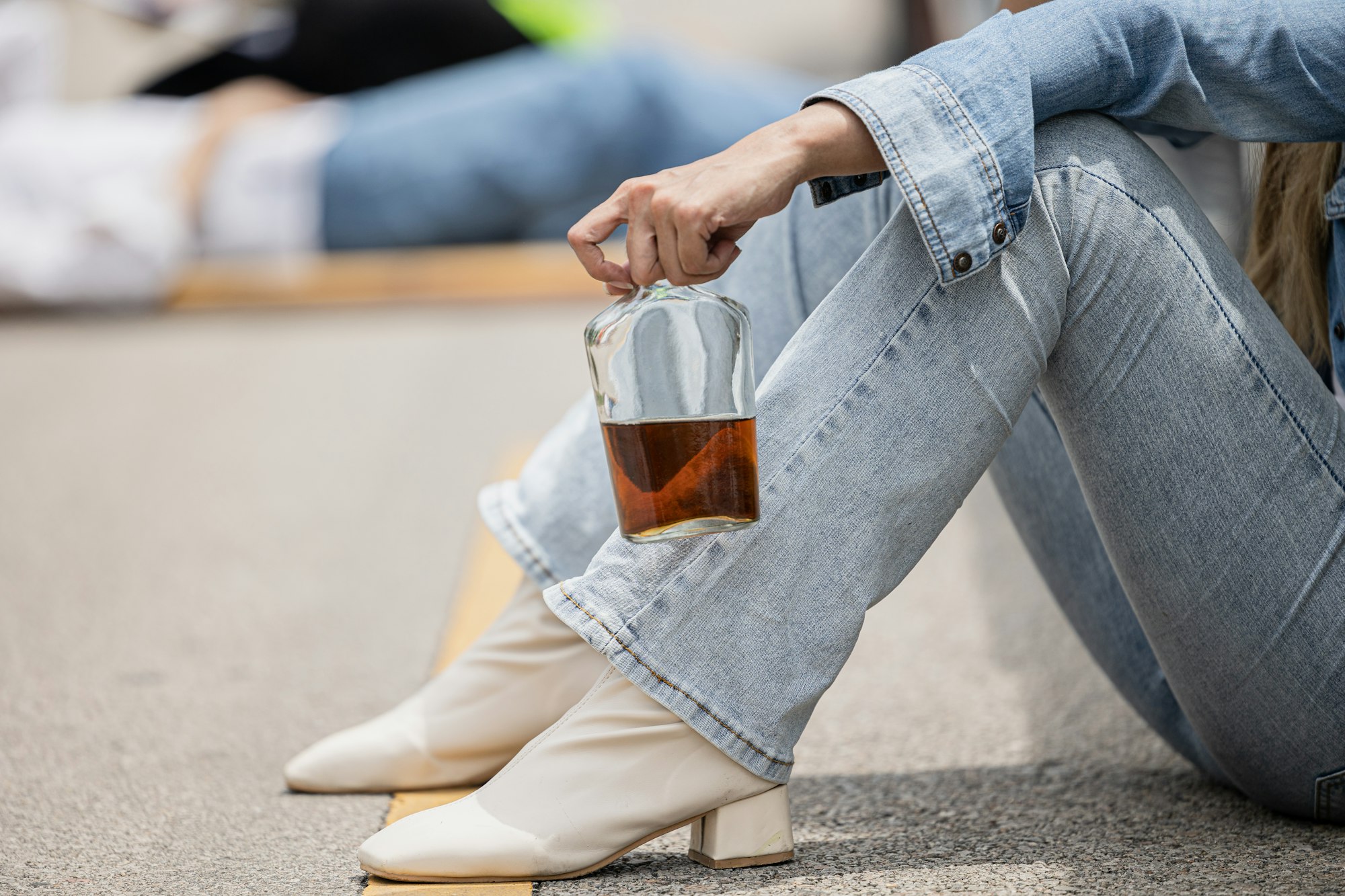 closeup woman drunk driver with whisky bottle drink during drive hit people accident background