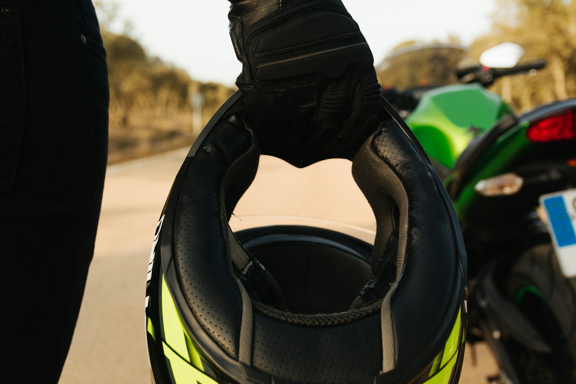Hand of a biker unrecognizable with a glove holding the protective helmet