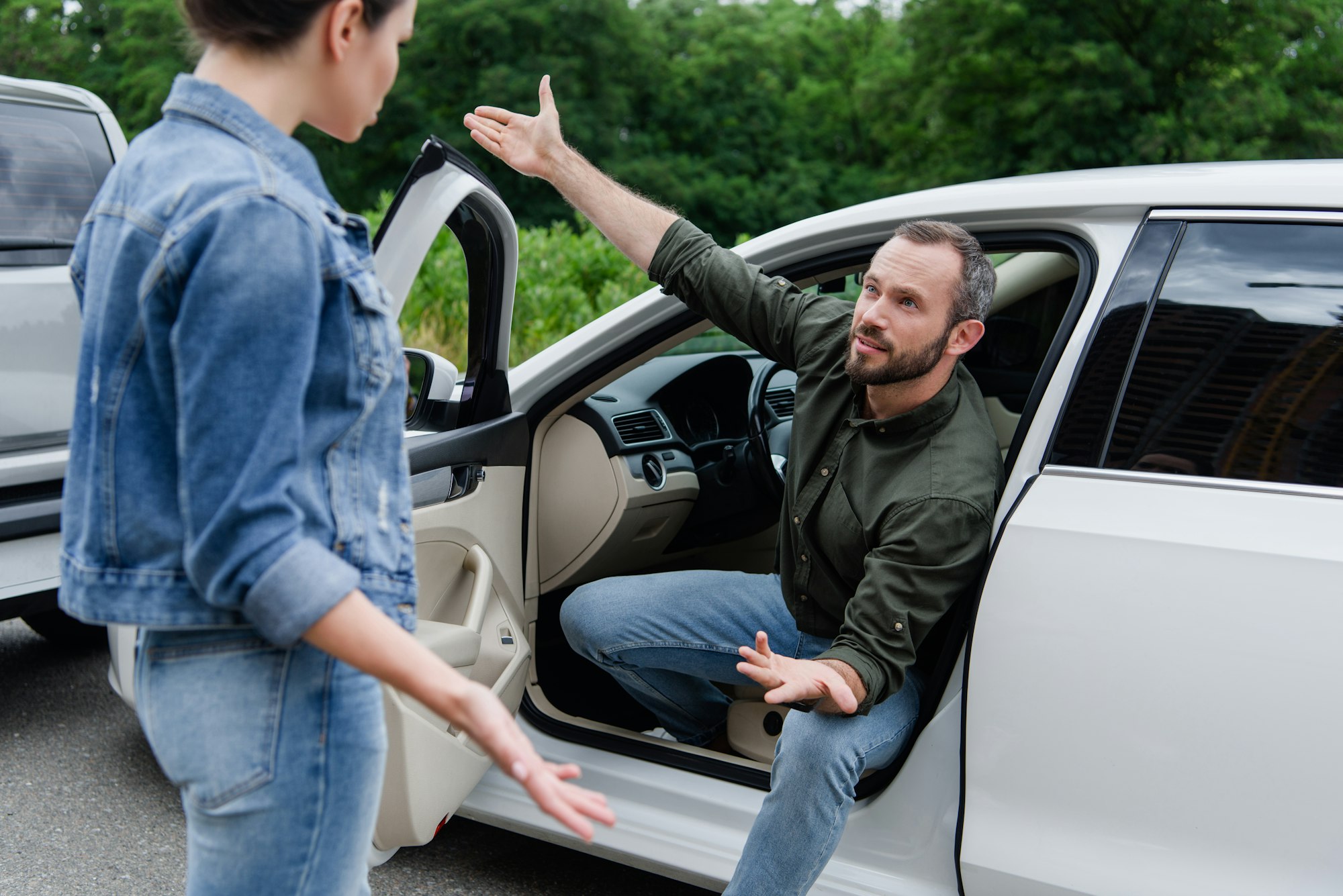 male and female drivers quarreling on road after car accident