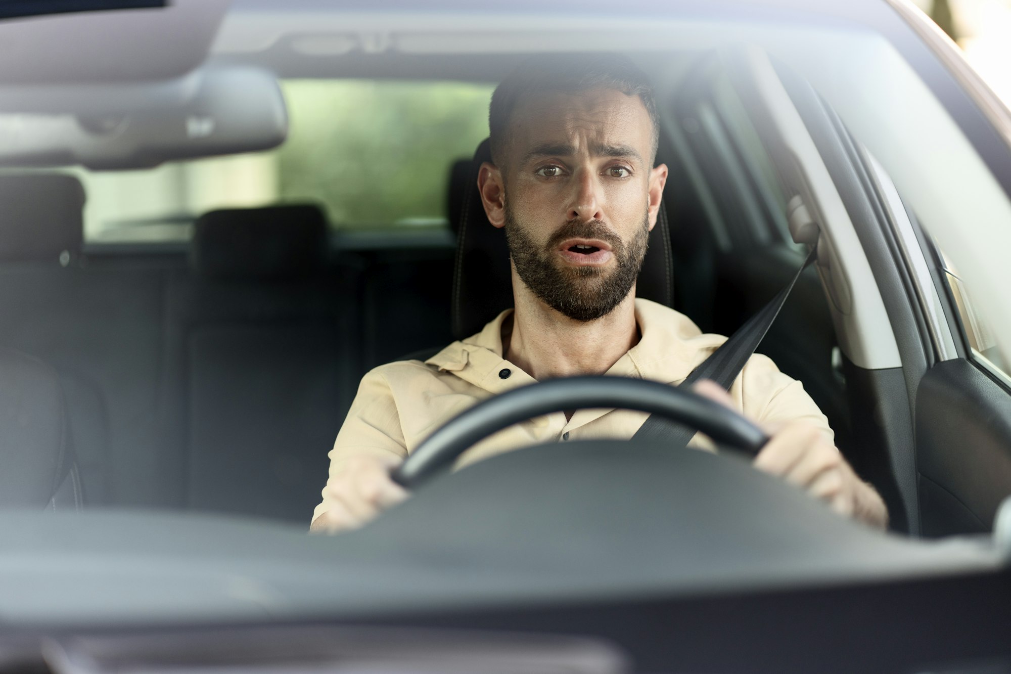 Man driving a car, had an accident. Sad driver stuck in traffic. Transportation concept