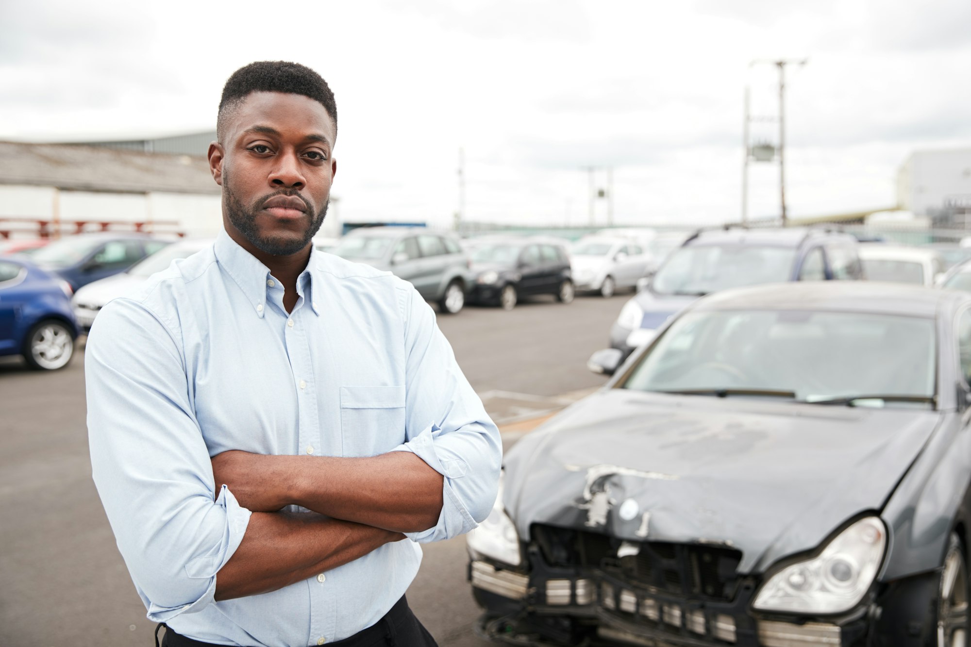 Portrait Of Motorist Standing Next To Car Damaged In Motor Accident