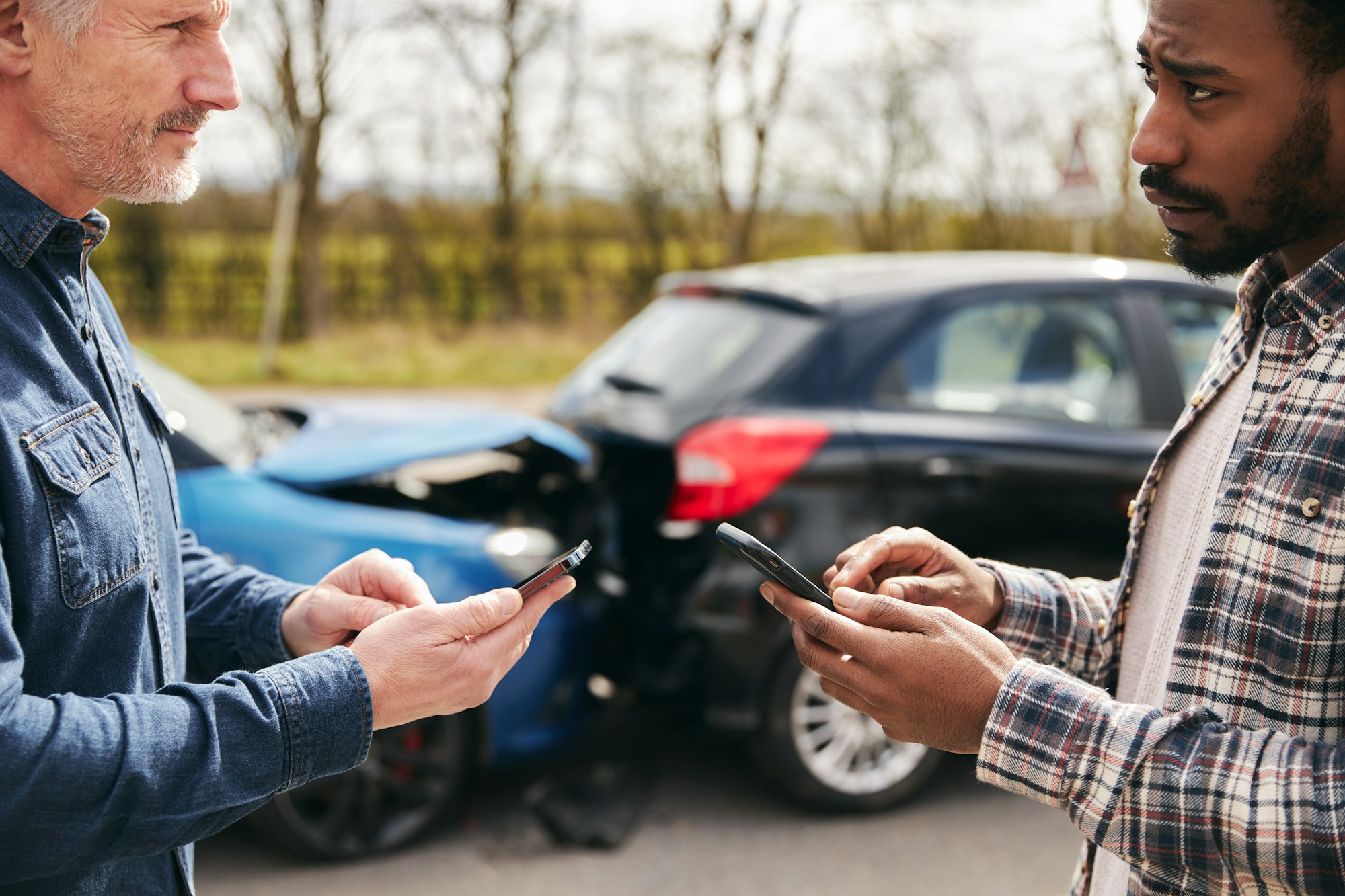 Senior Male Driver Exchanges Car Insurance Details With Younger Motorist After Road Traffic Accident
