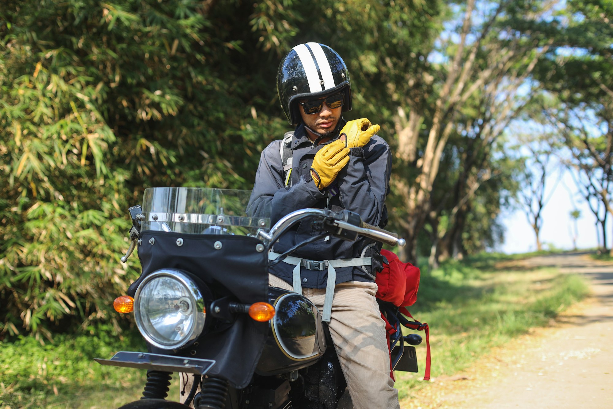 Young Asian man in a motorcycle wearing gloves. Safety riding concept.