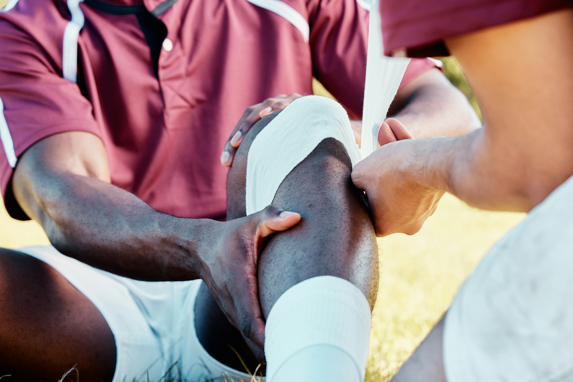 Knee pain, sport injury and bandage on athlete outdoor, rugby and fitness with black man, team and