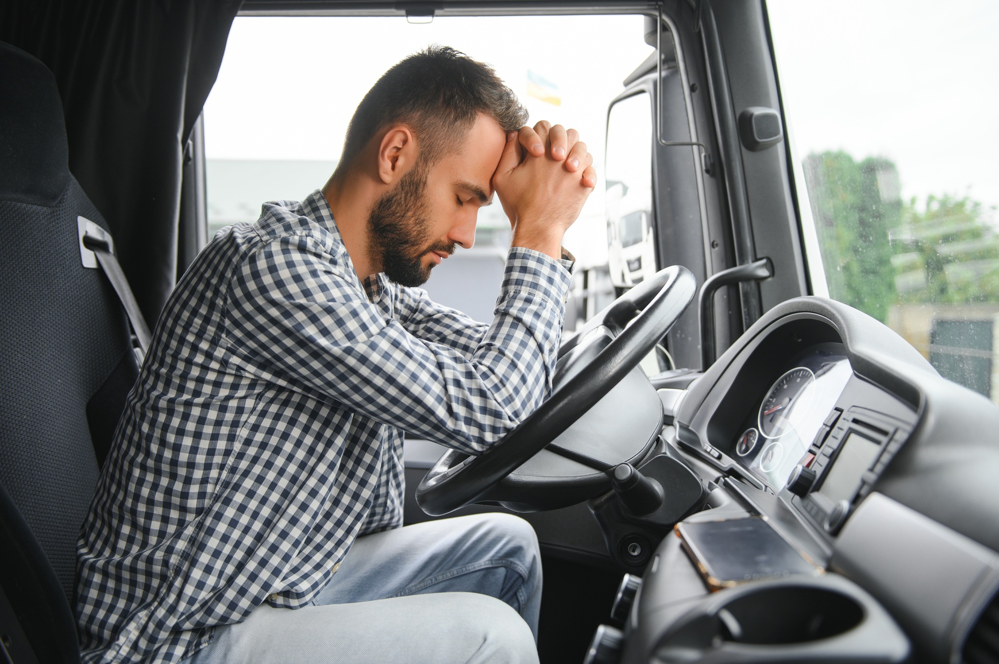 Man trucker tired driving in a cabin of his truck
