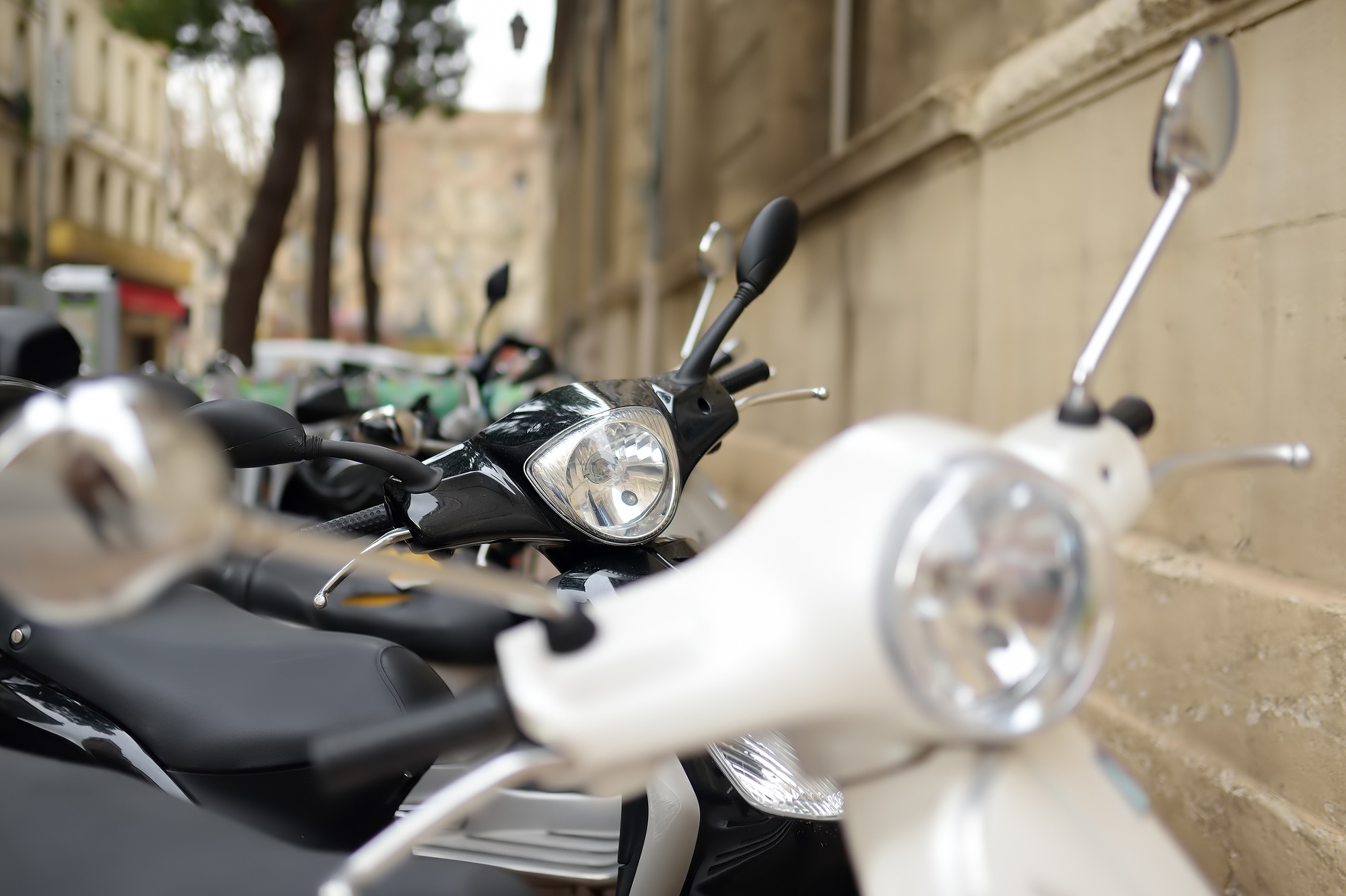 Motorcycle, scooters are parked on the narrow street. A problem of parking vehicles.