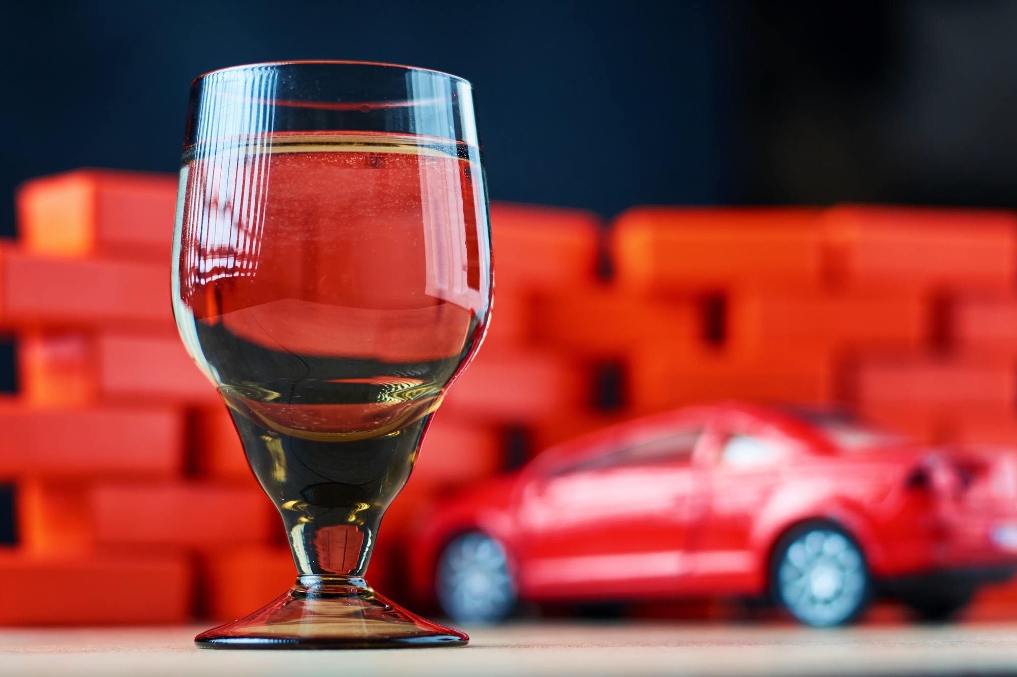 Drunk driving car crash accident. Don't drive after drink concept. Shot glass and a broken car