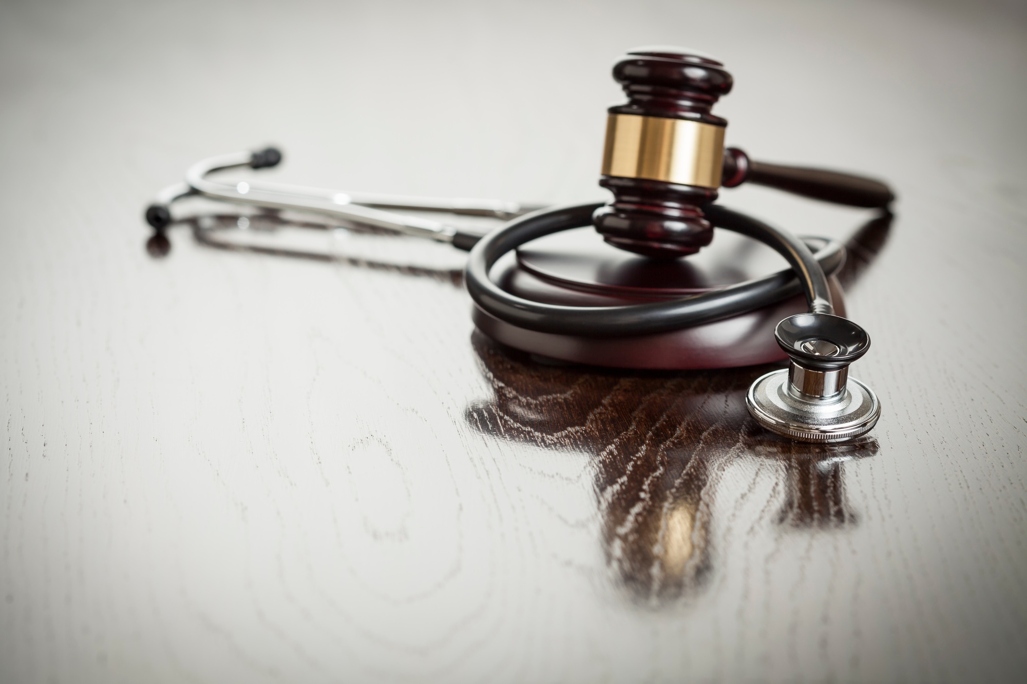 Gavel and Stethoscope on Reflective Table