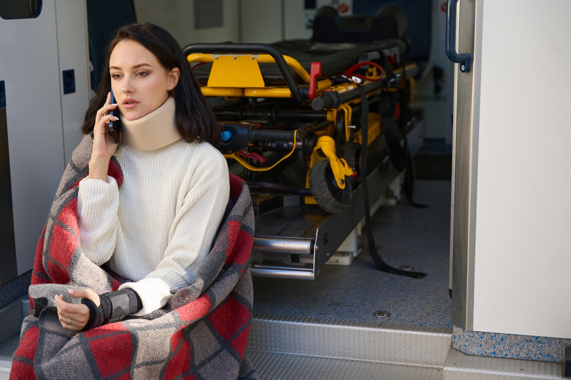 Woman with bandage around neck reports an accident on phone