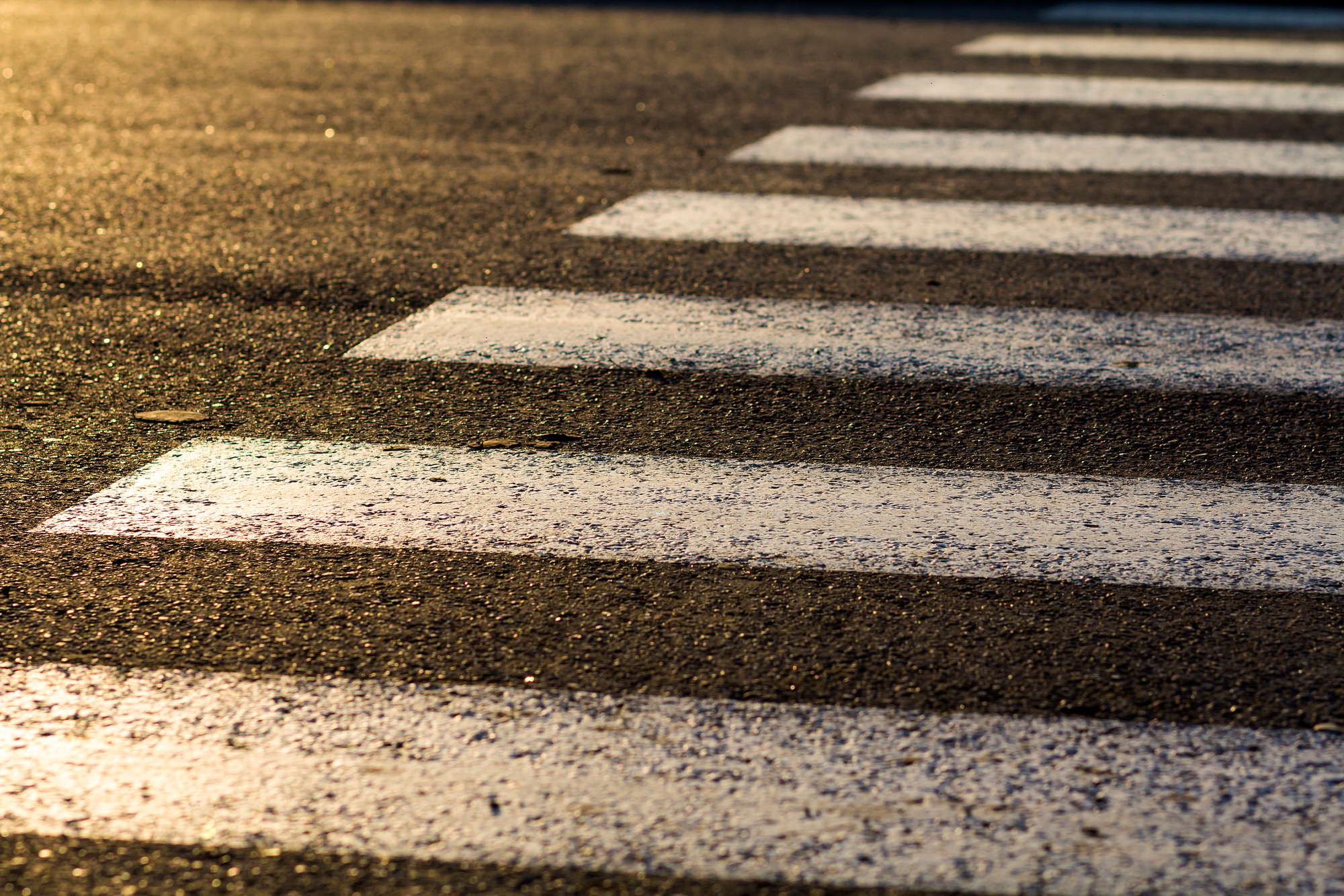 Detail of dangerous road crossing with pedestrian zebra. Safety concept.