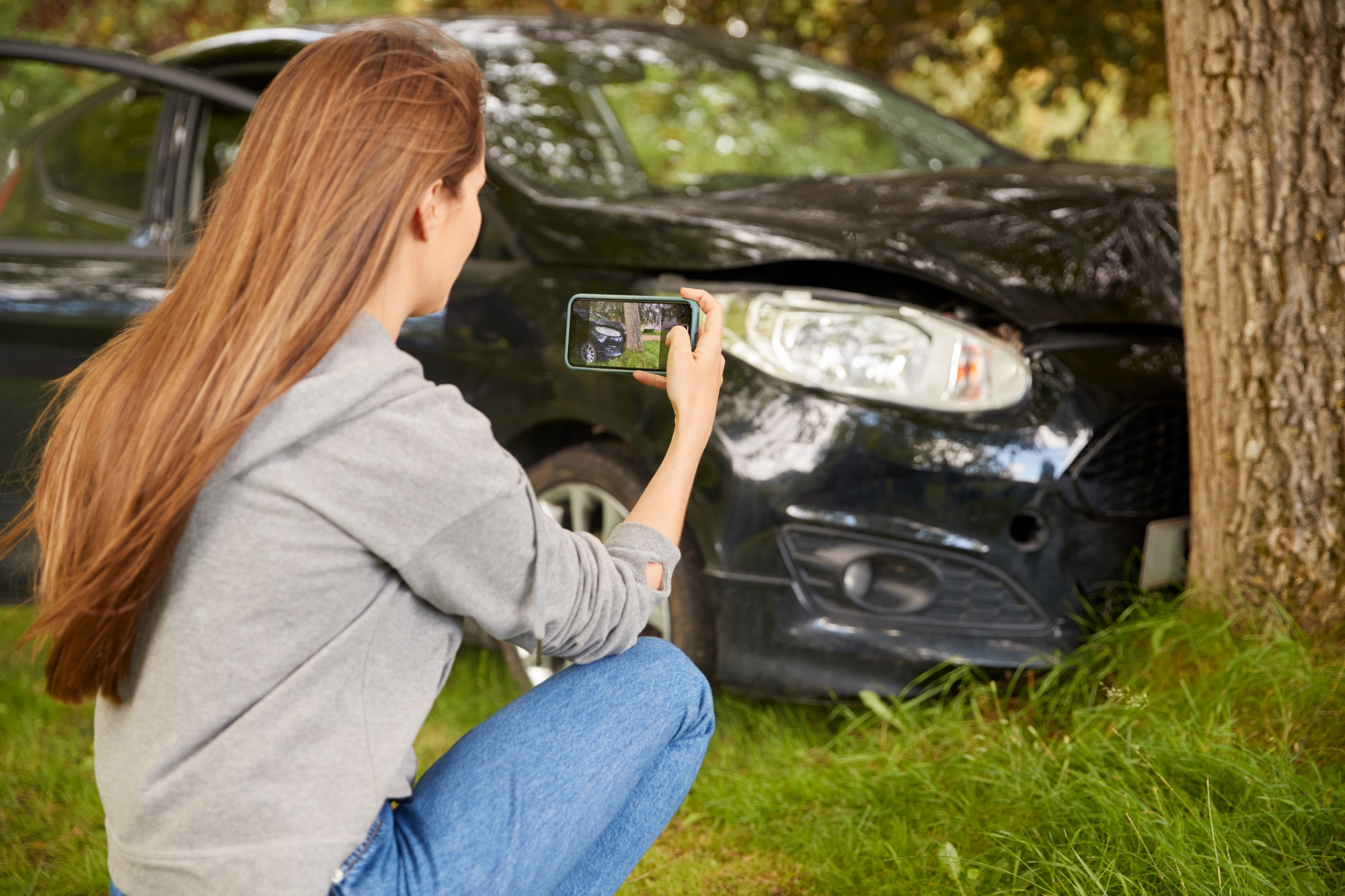 Woman Gets Out Of Smoking Car And Takes Photo Of Accident Damage On Mobile Phone