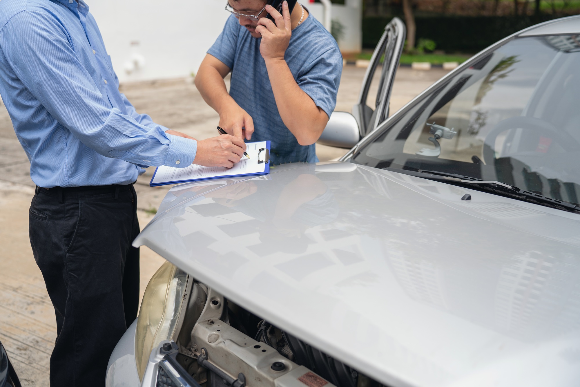 Insurance officer writing Insurance Claim Report on clipboard while insurance. Man and Insurance