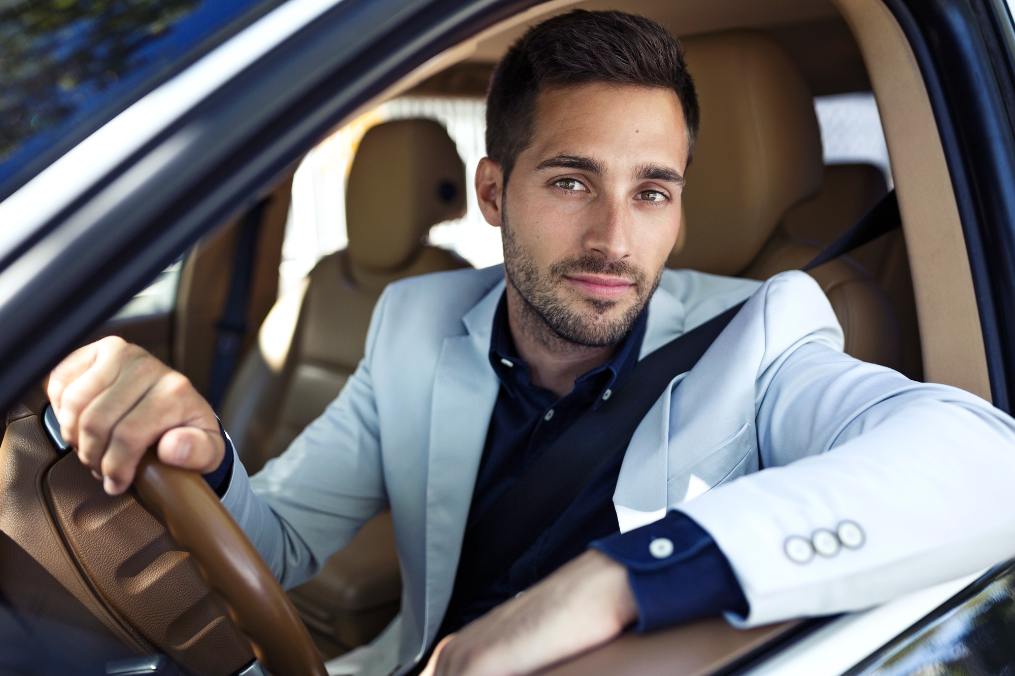 Successful young businessman driving in his car