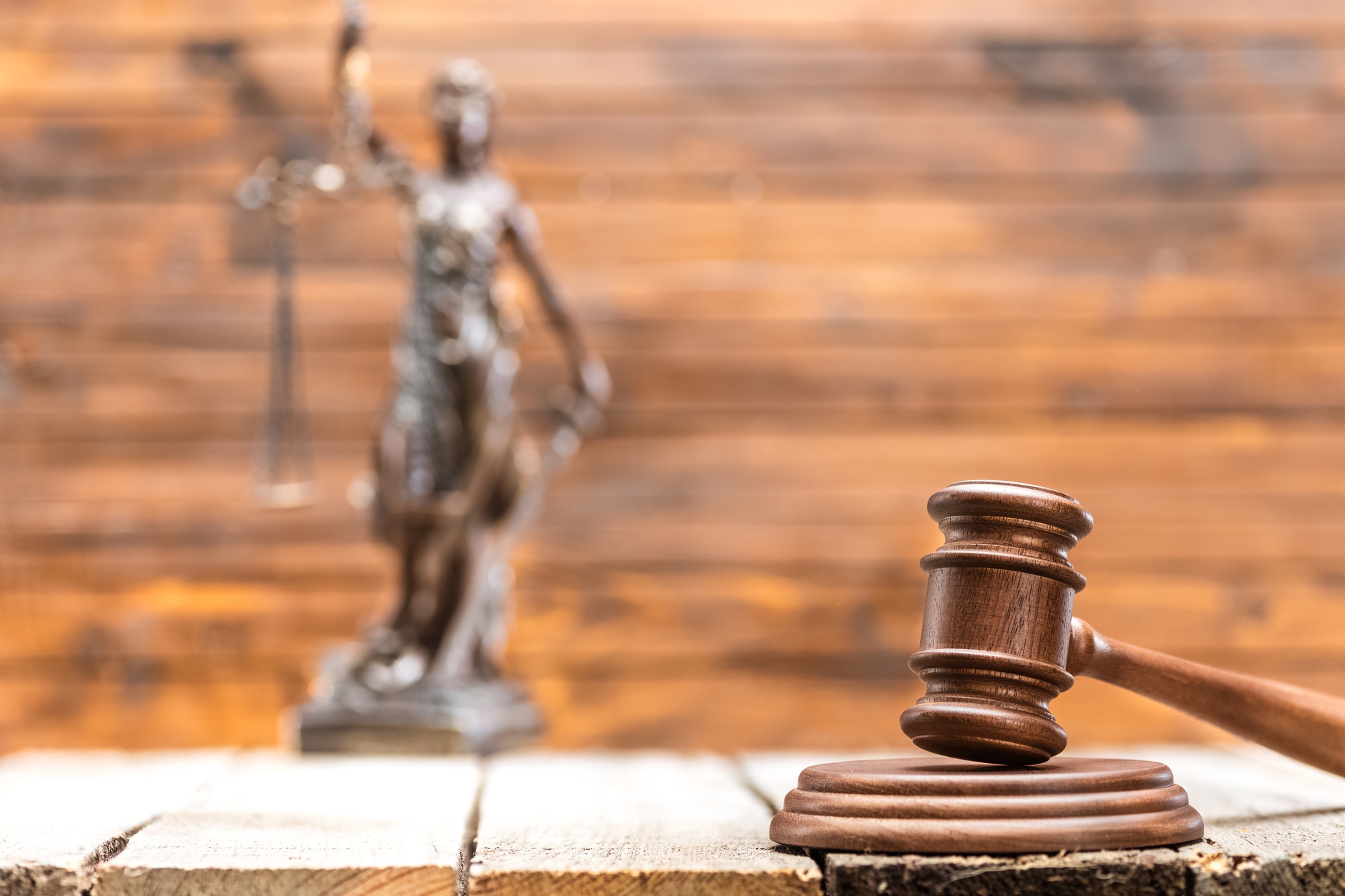 Close-up view of brown wooden mallet of judge on wooden table, law concept