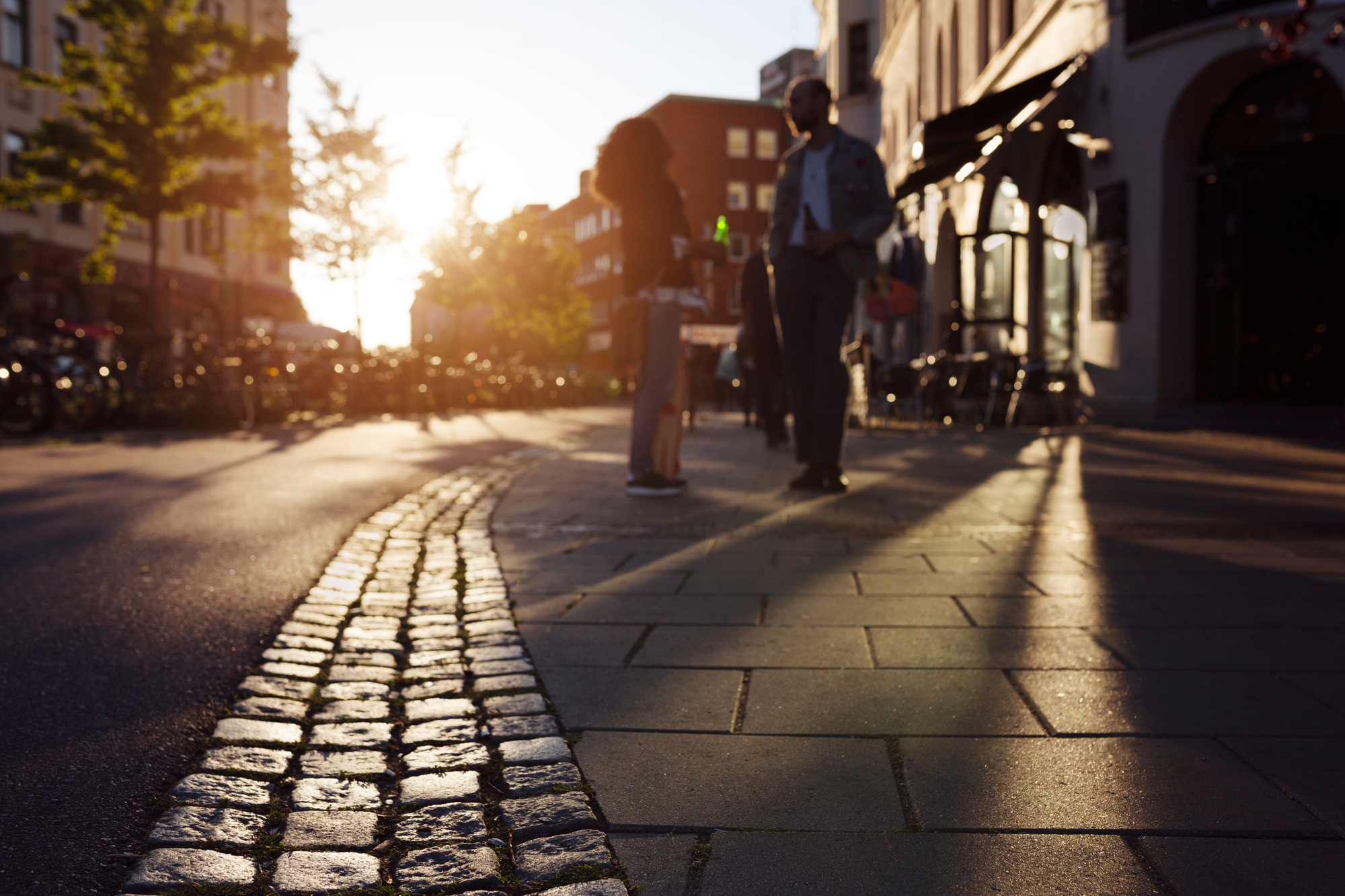 Friends standing on sidewalk and talking