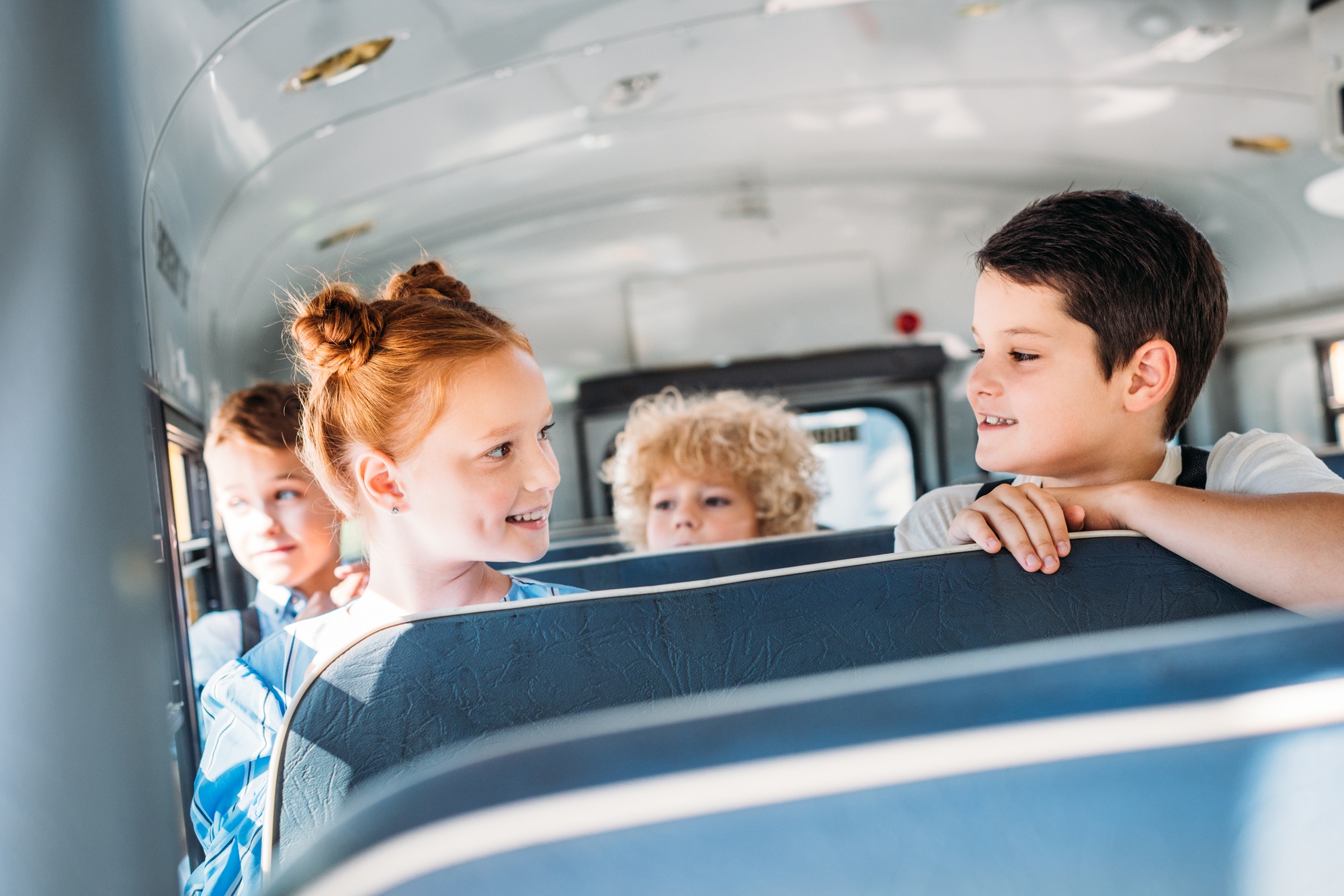 group of happy little pupils riding on school bus