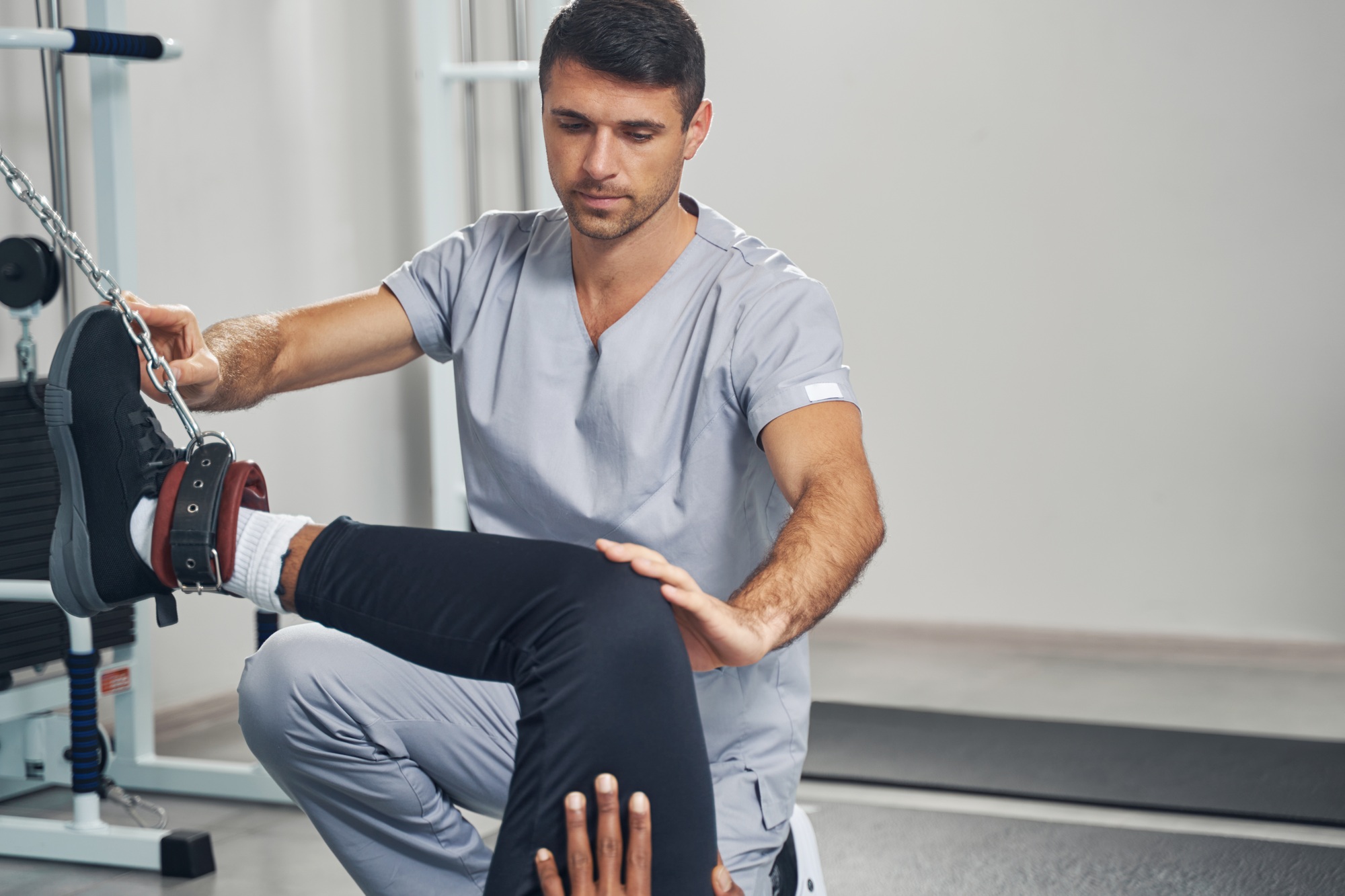 Physiatrist rehabilitating African American man after leg injury